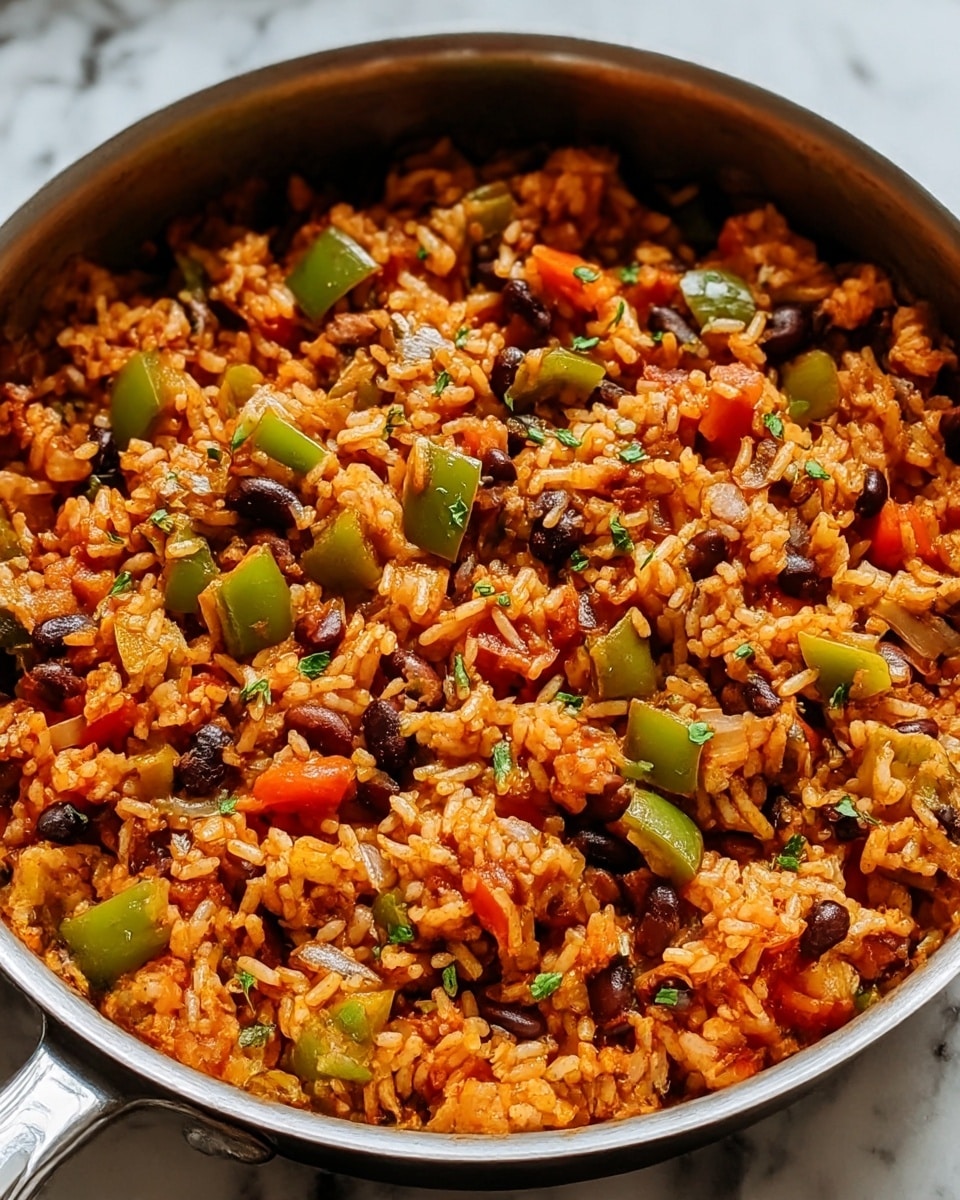 A close-up view of a pan filled with cooked rice mixed with diced green bell peppers, black beans, onions, and small pieces of red tomatoes, all coated in a reddish-orange sauce, garnished lightly with green herbs scattered on top; the pan is silver with a handle and sits on a white marbled surface, showing the texture of the rice and vegetables clearly. photo taken with an iphone --ar 4:5 --v 7