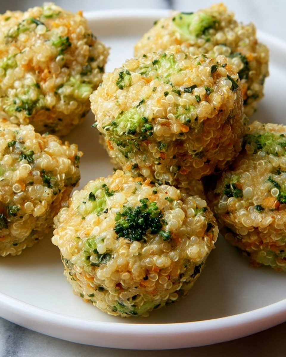 The image shows several small muffin-shaped bites made of cooked quinoa mixed with finely chopped broccoli and possibly cheese, giving a light golden color with green broccoli pieces scattered throughout. Each muffin is compact, slightly textured, and sitting closely together on a shiny, white plate with a curved edge. The surface beneath the plate resembles a white marbled texture. The lighting highlights the moist yet firm texture and the small vegetable bits within the muffins, making them appear fresh and homemade. photo taken with an iphone --ar 4:5 --v 7